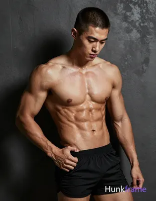 A white man with a short buzz cut in dark brown/black stands shirtless against a