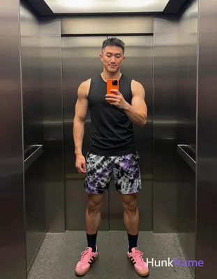 Asian man with medium-dark skin and short black straight hair stands in a full-body vertical mirror 