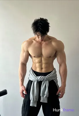 Asian man with light tan skin and short dark tousled hair stands upright in an i