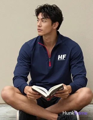 Asian man with medium-tan skin, dark wavy hair side-swept across forehead, clean-shaven face holding