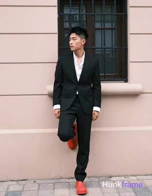 Asian man, short black textured hair spiky on top tapered sides clean-shaven neutral contemplative g