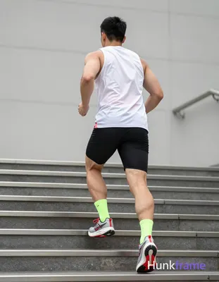 An adult man runs up metal stairs, viewed from behind and slightly to the left. 