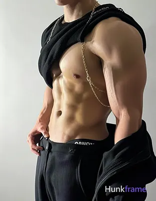 torso angled left; He is shirtless with pectorals fully exposed and defined abs 