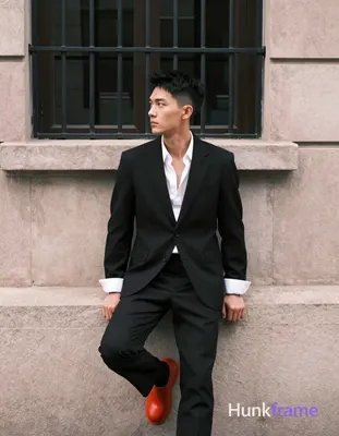 Asian man, short black textured hair tapered sides clean-shaven neutral contemplative gaze leftward 