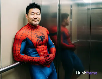 Asian man with light-medium skin and black short spiky hair, clean-shaven face neutral to slight smi