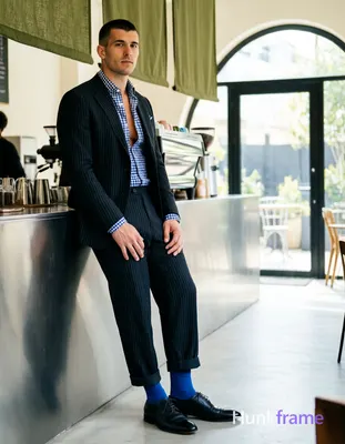 an anonymous figure man standing casually leaning against coffee bar counter in modern cafe interior