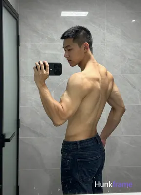 Asian man with short black buzz cut and clean-shaven face, standing sideways facing left in a candid