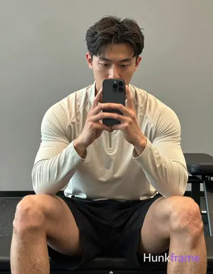 Asian man with light-medium skin and short dark wavy hair parted left, clean-sha