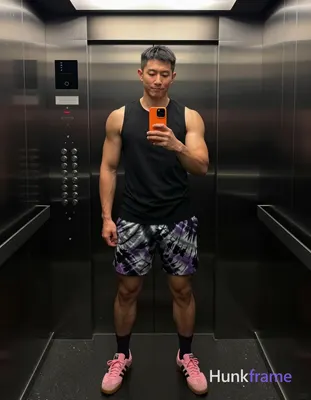Asian man with medium-dark skin and short black straight hair stands in a full-body vertical mirror 