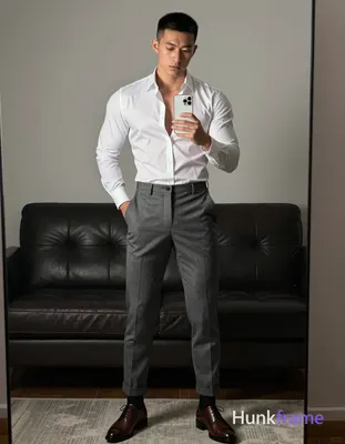 Asian man standing in front of full-length mirror holding white smartphone at ch