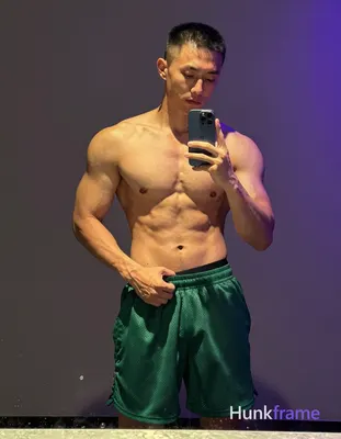 Asian man with light to medium tan skin and short buzz cut stands shirtless befo
