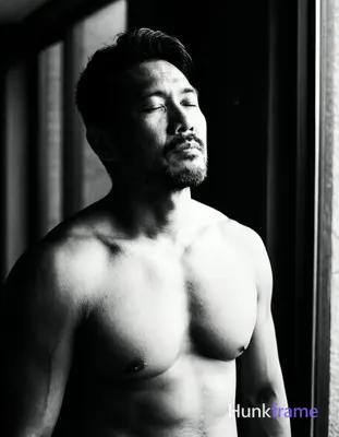 An Asian man with medium-dark skin and a dark, short hairstyle styled upward sta