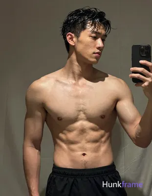 Asian man with short dark black slightly wavy wet-looking hair parted left, clean-shaven face neutra