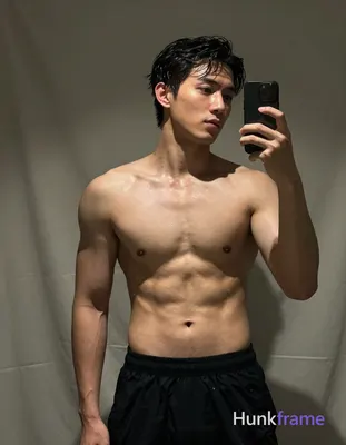 Asian man with short dark black slightly wavy wet-looking hair parted left, clean-shaven face neutra