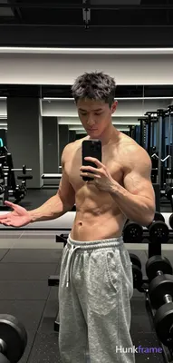 Asian man with short dark textured hair and clean-shaven face, shirtless displaying broad shoulders 