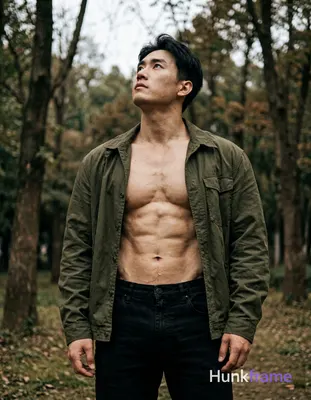 handsome Asian man standing with torso slightly leaned back and looking upwards, shirtless with bare
