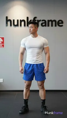 Asian man with short black buzz cut and high fade, clean-shaven face with neutral focused gaze stand