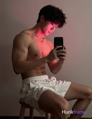 an anonymous figure man with short dark hair seated sideways on wooden stool, shirtless torso angled