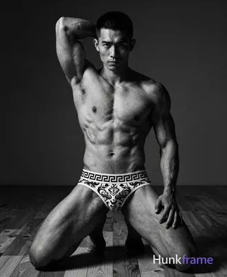 Asian man with medium-dark skin and a short textured black buzz cut, clean-shave