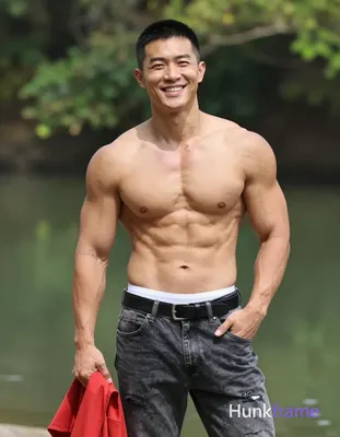 Asian man with light tan skin and short black buzz cut stands upright outdoors n