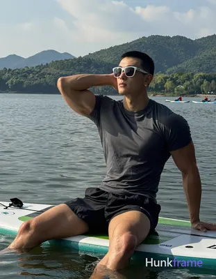Asian man with short buzz cut and white-framed sunglasses arms pushed up behind 