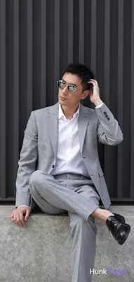 Asian man in a light gray suit jacket, notched lapel, single-button closure with