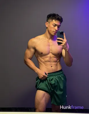 Asian man with light to medium tan skin and short buzz cut stands shirtless befo