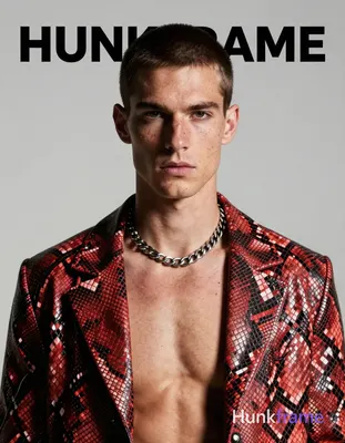 A white man with fair freckled skin and short dark cropped hair stands head-and-shoulders centered, 