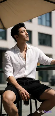 Asian man with light-medium skin, black short hair styled with volume on top and sides swept back, c