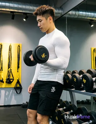 Asian man with light-medium skin and short textured dark brown crop hair stands in profile facing le