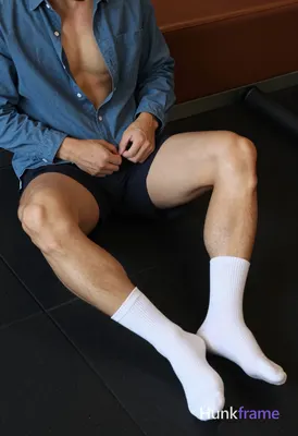 Seated adult man with light to medium tan skin and thick thighs, defined quadric