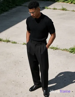 A handsome adult man with medium-dark skin and short dark hair featuring a textured top, faded sides