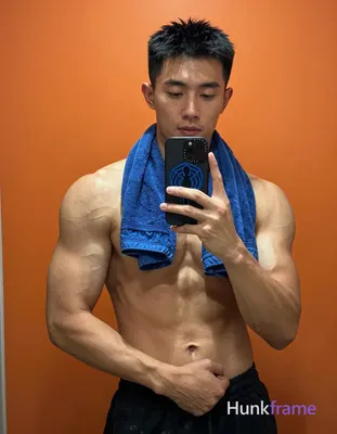 Asian man with light to medium tan skin and short black hair stands facing a mir
