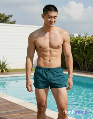 Asian man with short black buzz cut and high temples stands shirtless beside a swimming pool on a wo