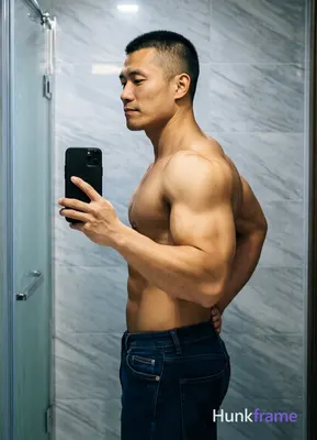 Asian man with short black buzz cut and clean-shaven face, standing sideways facing left in a high-r