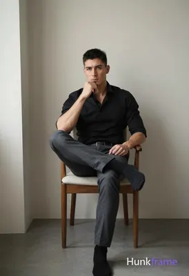 An athletic adult man with short black hair and clean-shaven face sits centered 