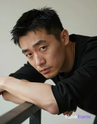 Asian man with light-medium skin texture and visible pores in tasteful suggestive framing, leaning f