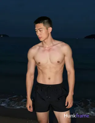 Asian adult man with short buzz cut and clean-shaven face, shirtless standing up