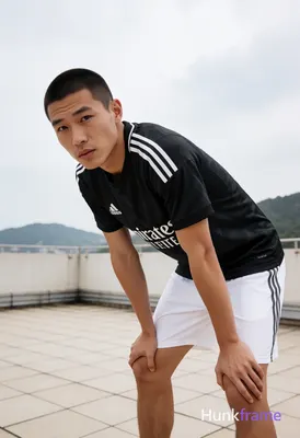 Asian man with short buzz cut and matte dark brown hair, clean-shaven face, neut
