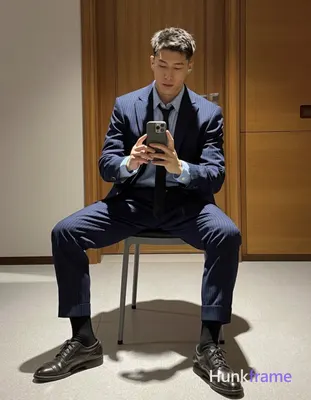 Asian man with light to medium tan skin and short textured dark hair, clean-shaven face holding a sm