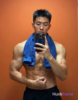 Asian man with light to medium tan skin and short black hair stands facing a mir