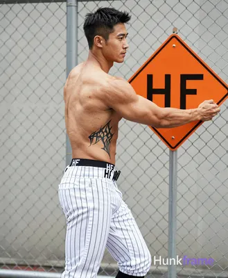 Asian man with short black hair, clean-shaven face, and light tan skin stands in profile facing righ