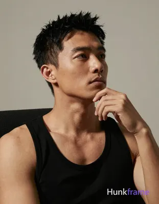 Asian man with medium-tan skin and short textured black hair, contemplative pensive gaze directed up