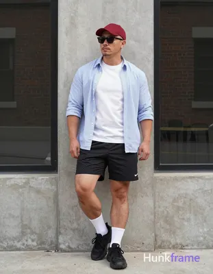 Asian man with light-medium skin and short buzz cut standing upright leaning against a concrete pill
