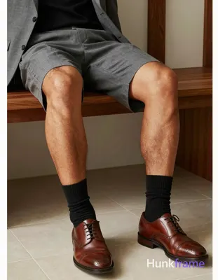 Seated male subject, legs extended resting on a low wooden table with left leg s