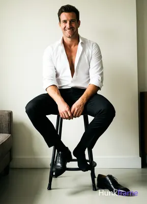 White button-down shirt sleeves rolled to elbows, top buttons undone revealing bare chest from colla