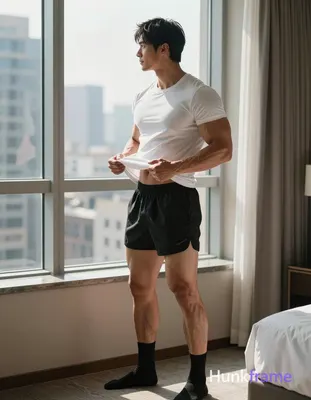 A muscular adult man with short black straight hair and side-parted bangs stands