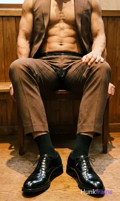 Candid lifestyle photo of a handsome masculine man seated with legs extended and crossed at the ankl