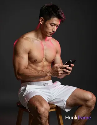 Asian man with tanned skin and short dark hair, clean-shaven chin with light stubble on jawline; Shi