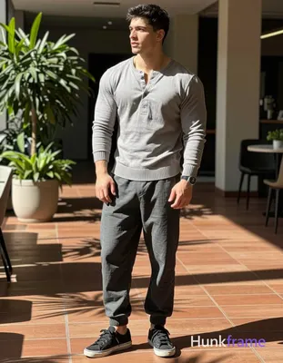 grey long-sleeve henley sweater with ribbed hem over dark grey loose-fitting trousers and black low-